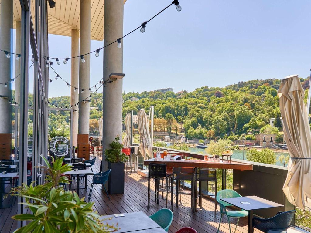 a patio with tables and chairs on a balcony at Novotel Lyon Confluence in Lyon
