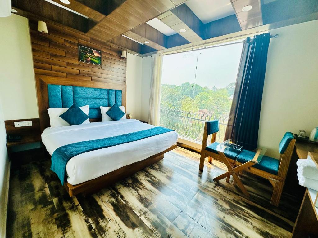 een slaapkamer met een bed en een groot raam bij Hotel Royal Orbit in Dehradun