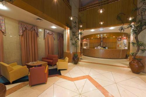 A reception lobby with colorful lounge chairs and curtained windows.