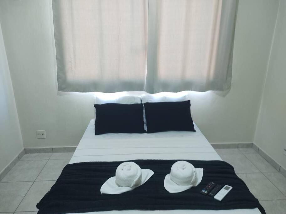 a bed with two hats on top of it at Kitinet Verolme AFP 1 in Angra dos Reis