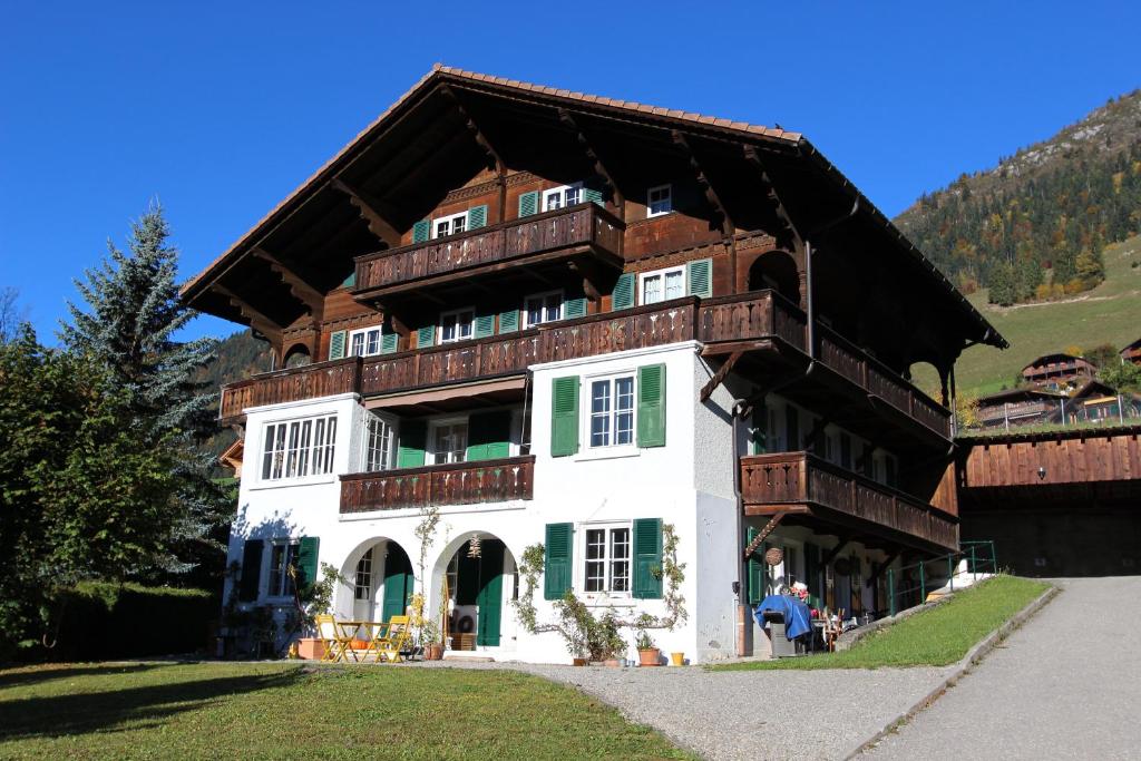 uma grande casa de madeira com um telhado de gambrel em Arnica 1 em Chateau-d'Oex