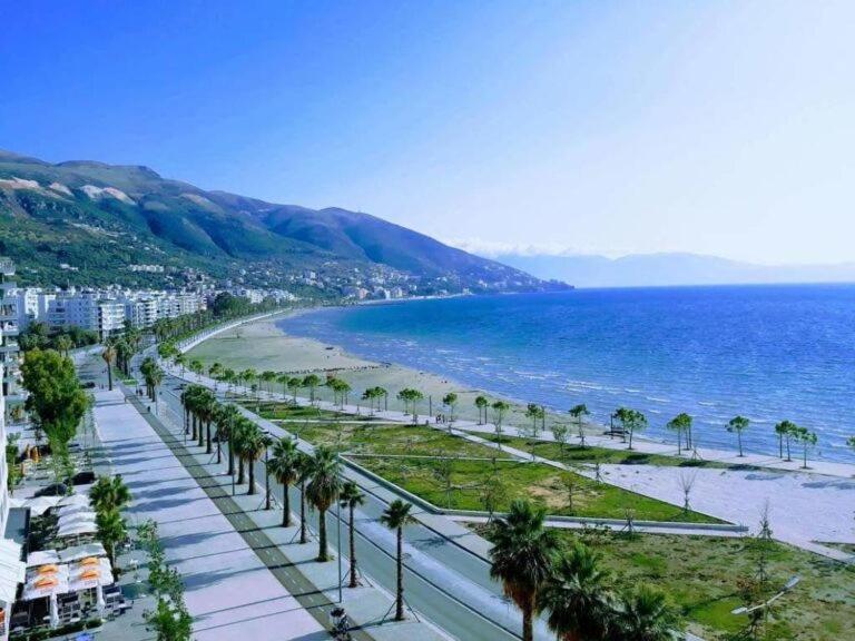Una vista de una playa con palmeras y el océano. en Luxury Apartment Hannah, en Vlorë