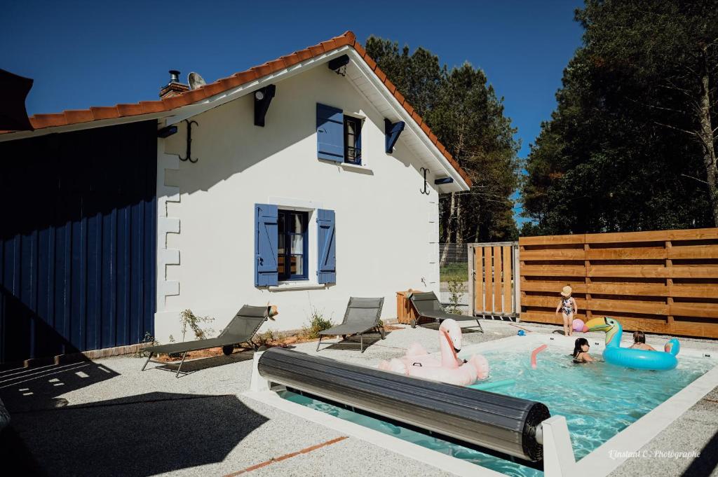 a pool with pink inflatable flamingos in a backyard at La Maison de Marie in Saint-Julien-en-Born
