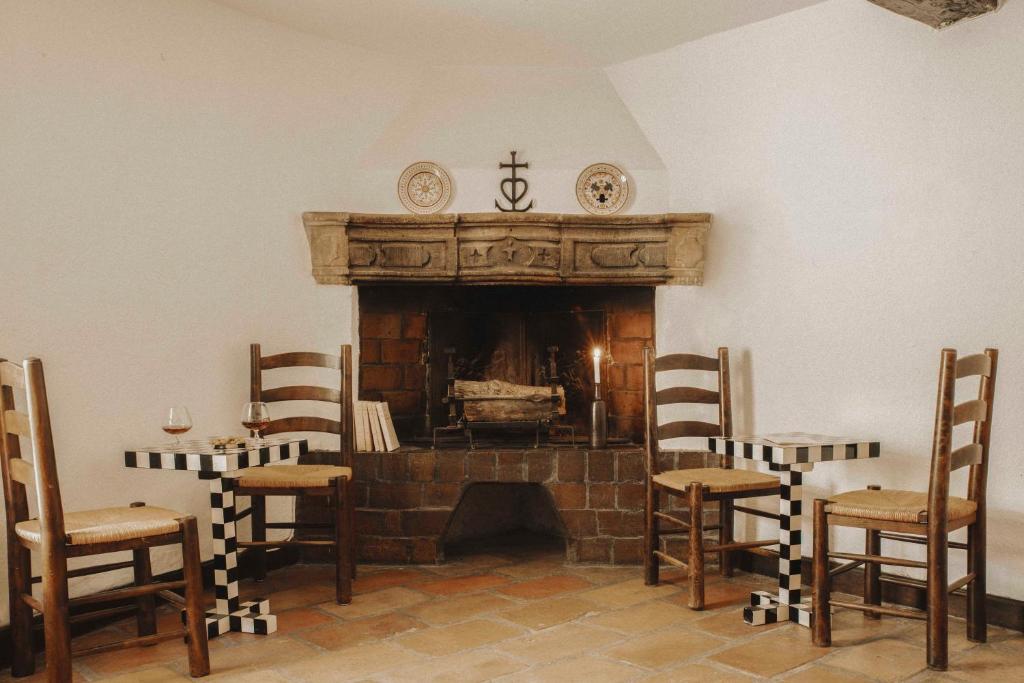 sala de estar con chimenea y sillas en Les Bains Gardians, en Saintes-Maries-de-la-Mer