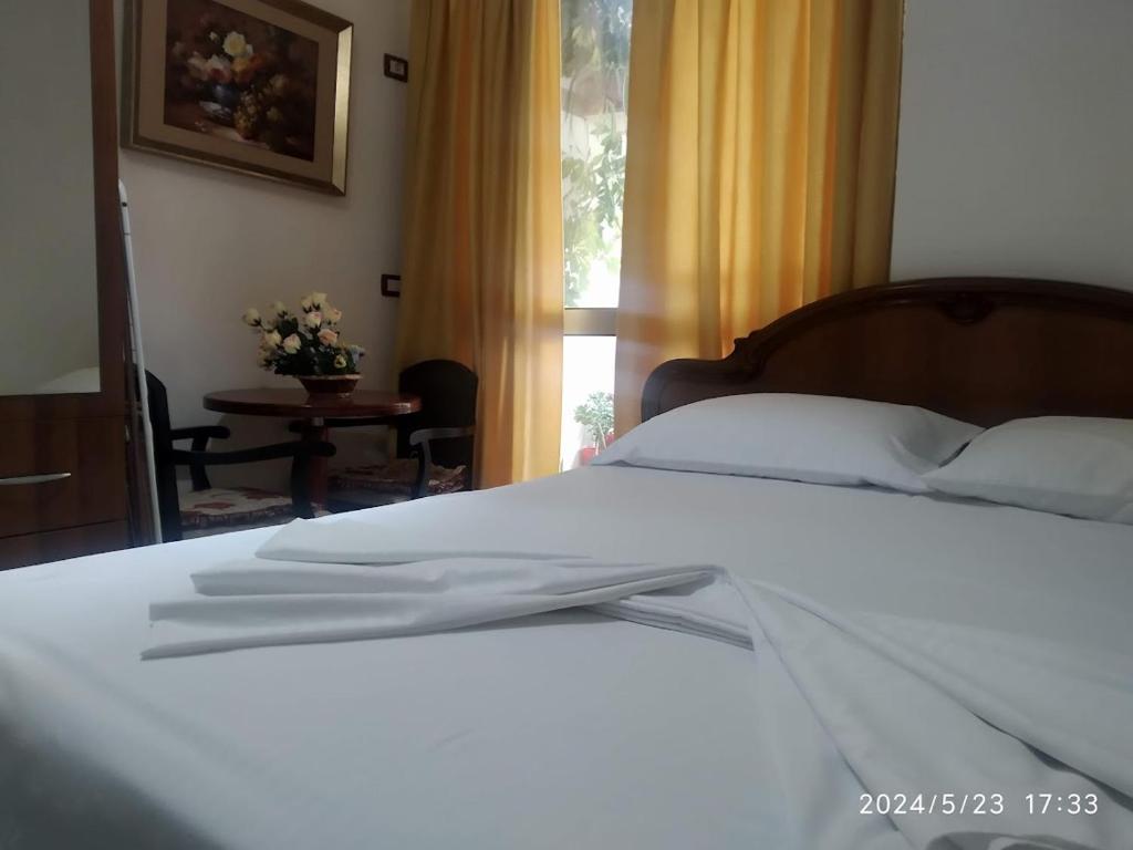 - une chambre avec un lit blanc et une fenêtre dans l'établissement Holiday apartment Shengjin, à Shëngjin