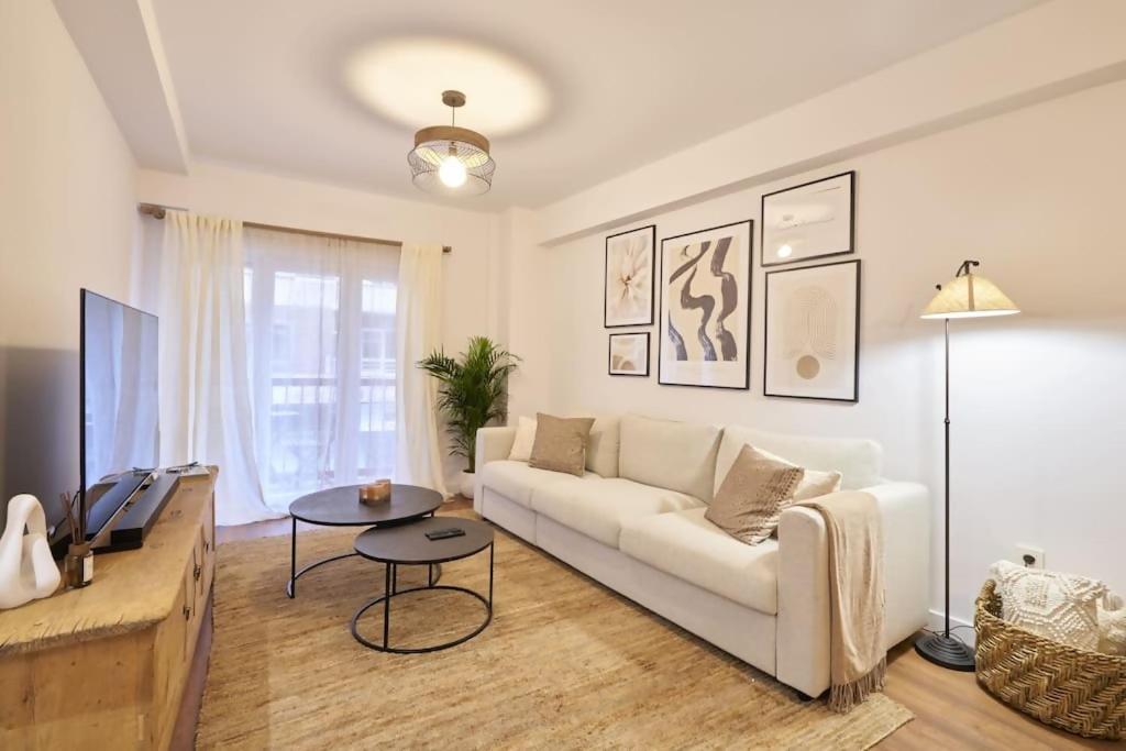 a living room with a white couch and a table at El Balcón de Jauregui centro in Salamanca