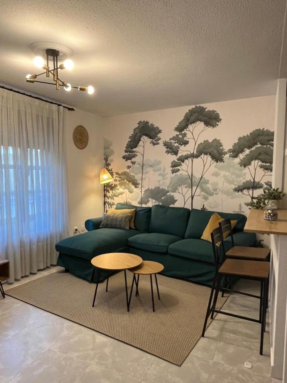 Una sala de estar con un sofá verde y una mesa. en Encantador apartamento Enlosado de Balborraz, en Zamora
