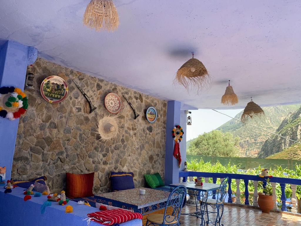 ein Wohnzimmer mit einem Tisch und einer Steinmauer in der Unterkunft Blue House Town in Chefchaouen