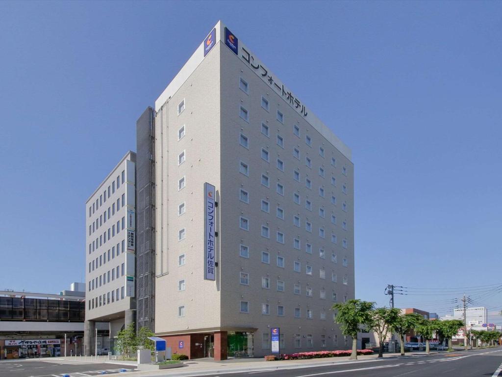 佐賀的住宿－佐賀康福特酒店，一条城市街道上高大的白色建筑