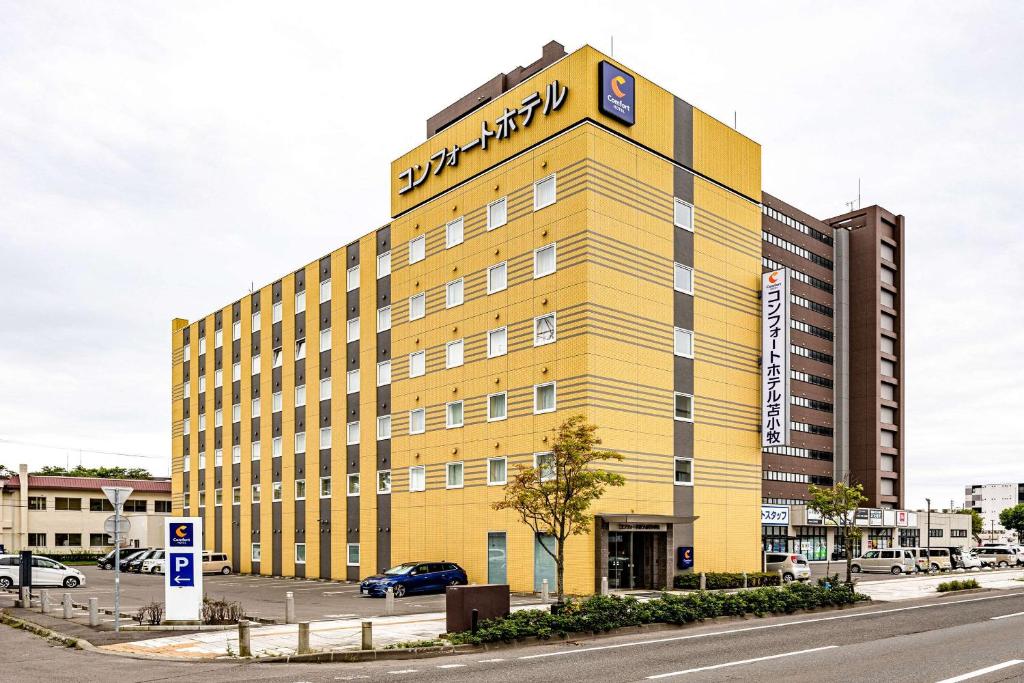 a yellow building with a sign on the top of it at Comfort Hotel Tomakomai in Tomakomai