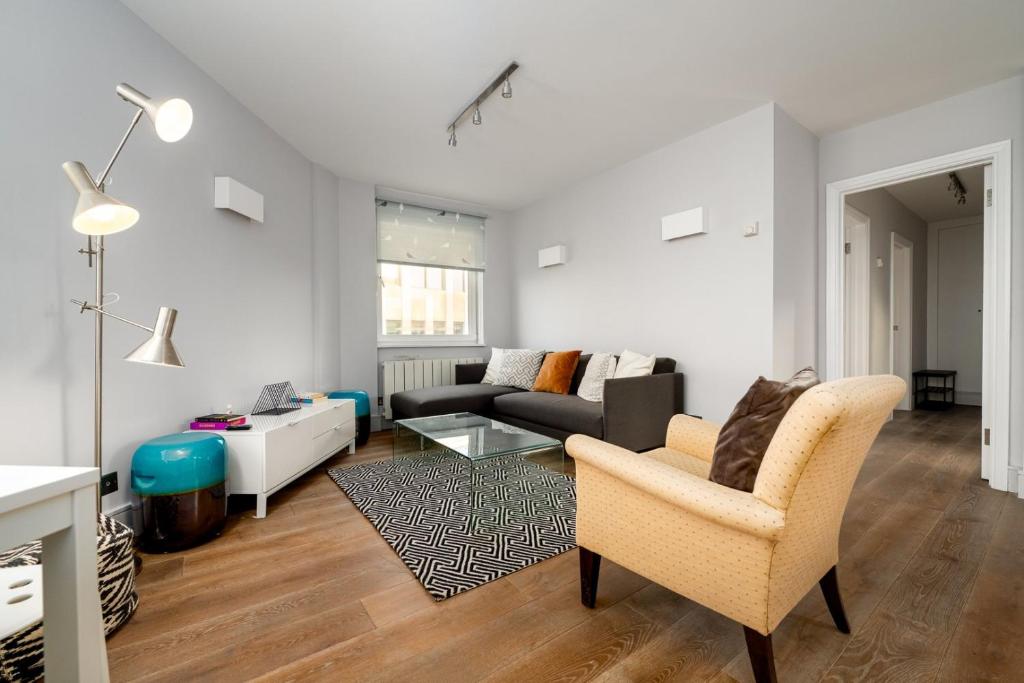 een woonkamer met een bank en een tafel bij GuestReady - Central Living near Kensington Palace in Londen