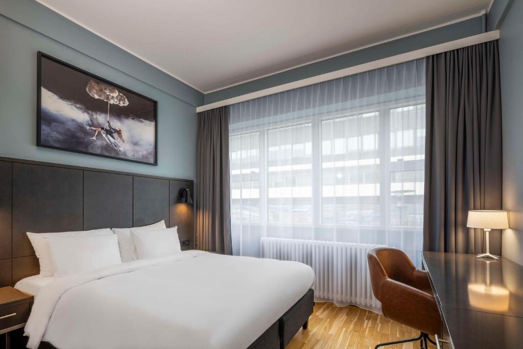 a hotel room with a large bed and a window at Radisson Blu 1919 Hotel, Reykjavík in Reykjavík