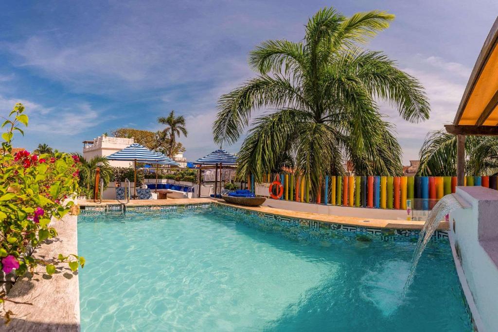een zwembad met een palmboom en een fontein bij Hotel Bantu by Faranda Boutique, a member of Radisson Individuals in Cartagena