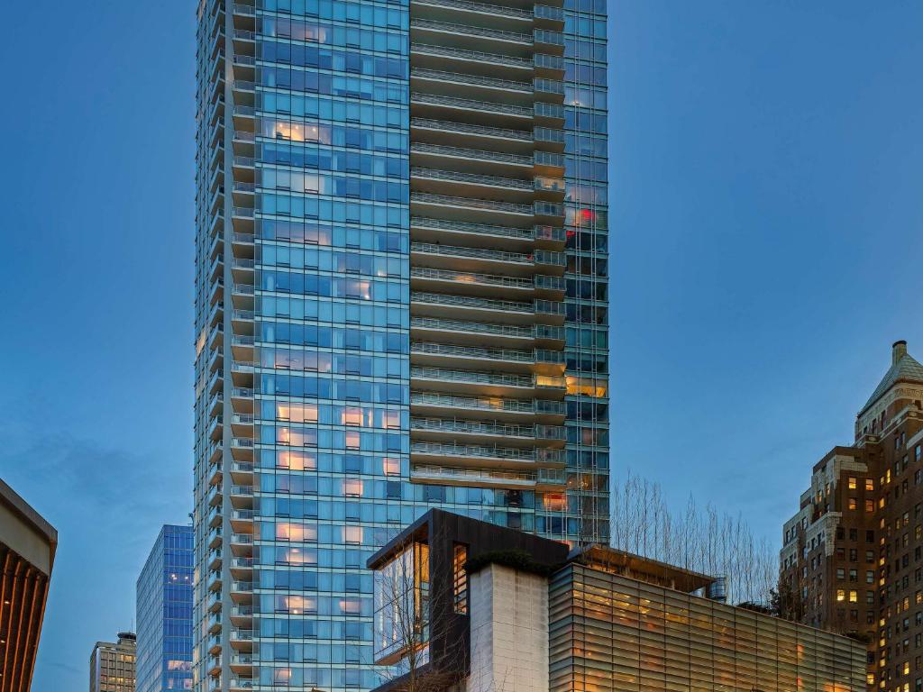 a tall skyscraper in a city with buildings at Fairmont Pacific Rim in Vancouver