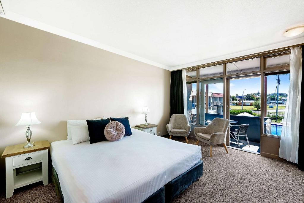 a hotel room with a bed and a balcony at Comfort Resort Waters Edge in Port Macquarie