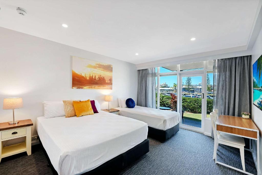a hotel room with two beds and a window at Comfort Resort Waters Edge in Port Macquarie