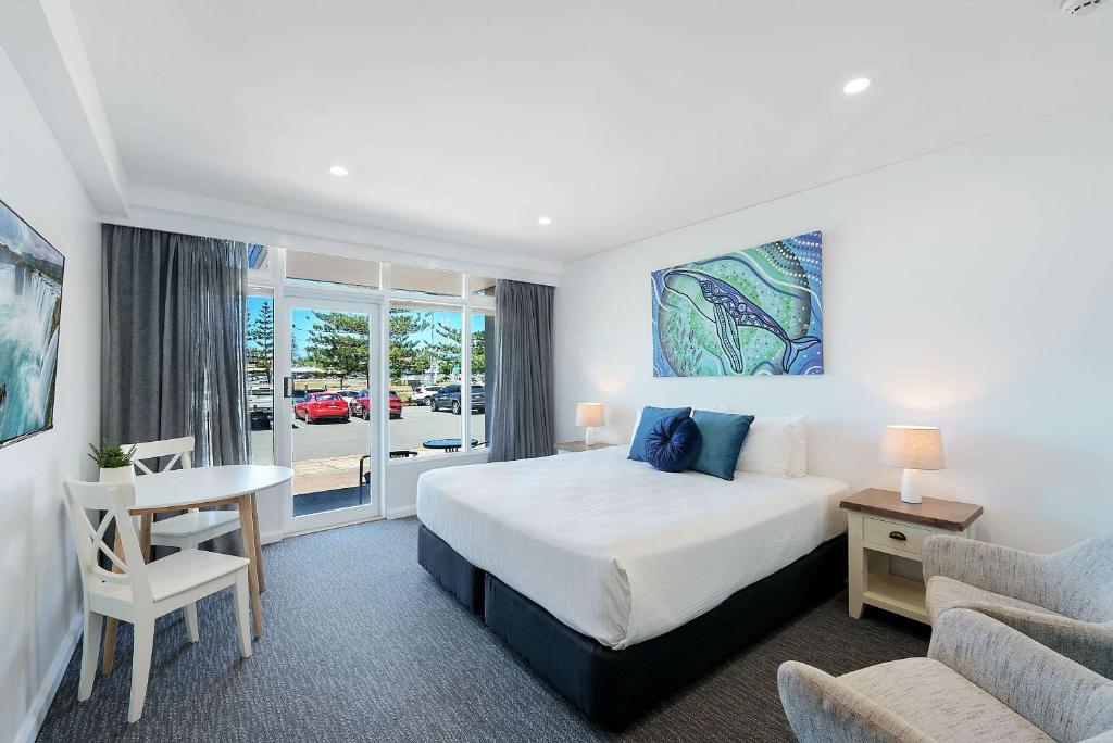 a bedroom with a bed and a table and a couch at Comfort Resort Waters Edge in Port Macquarie