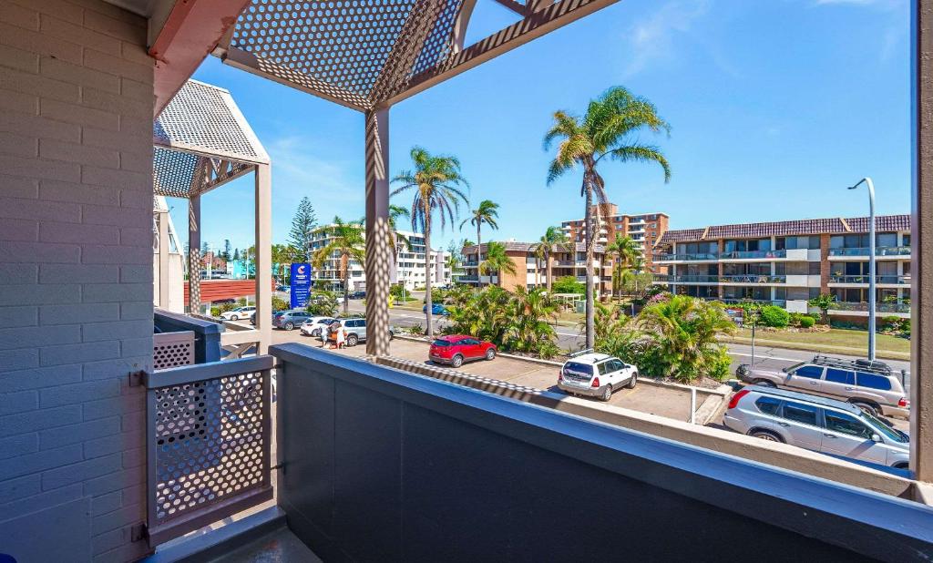 a balcony with a view of a street with palm trees at Comfort Resort Waters Edge in Port Macquarie