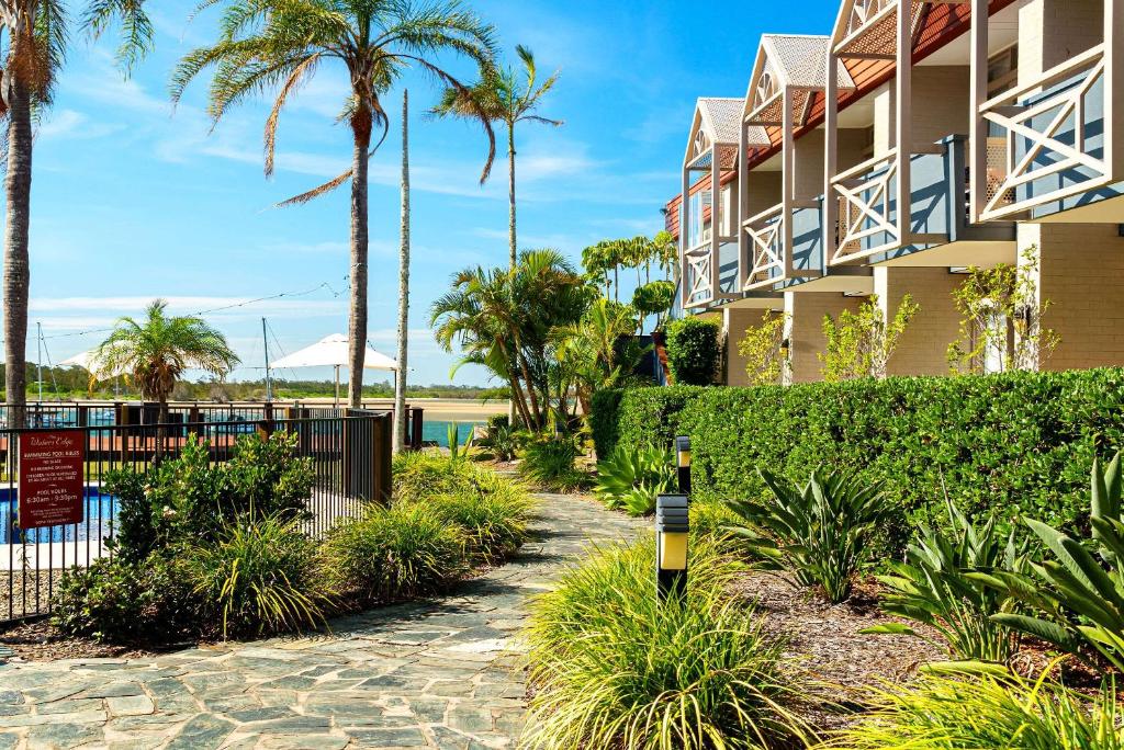 a parking meter in front of a building with palm trees at Comfort Resort Waters Edge in Port Macquarie