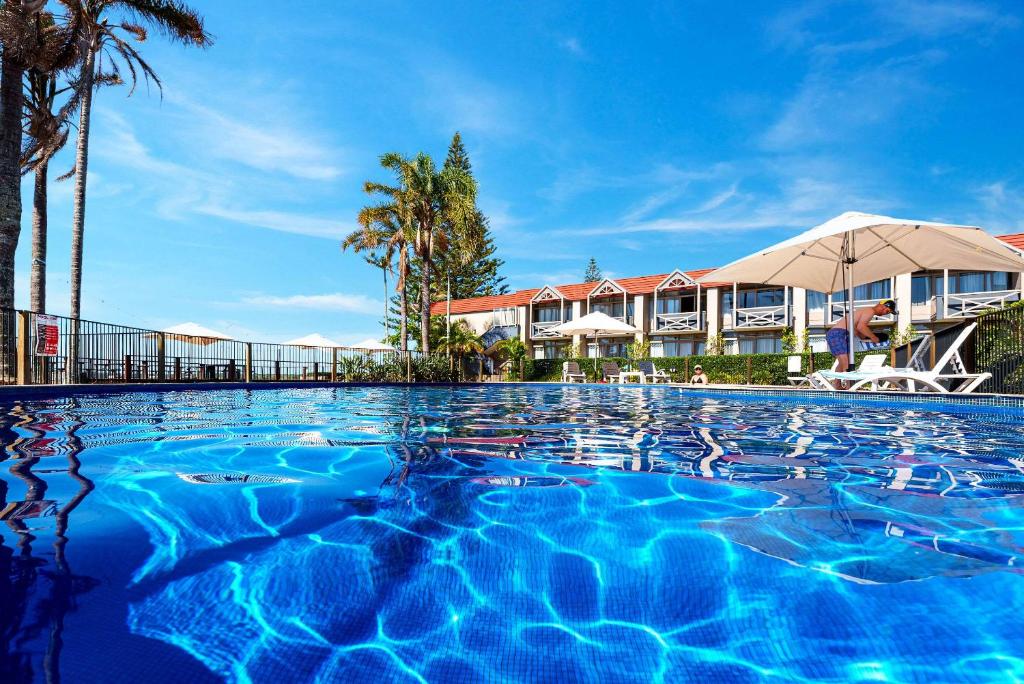 a swimming pool in front of a resort at Comfort Resort Waters Edge in Port Macquarie
