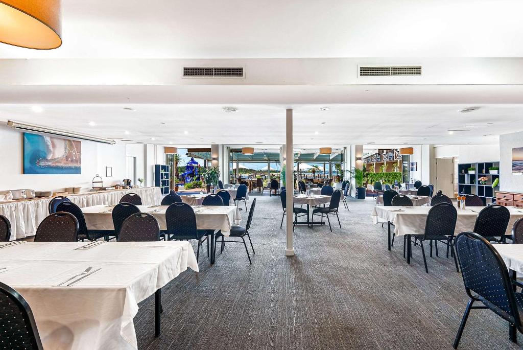 a dining room with white tables and chairs at Comfort Resort Waters Edge in Port Macquarie