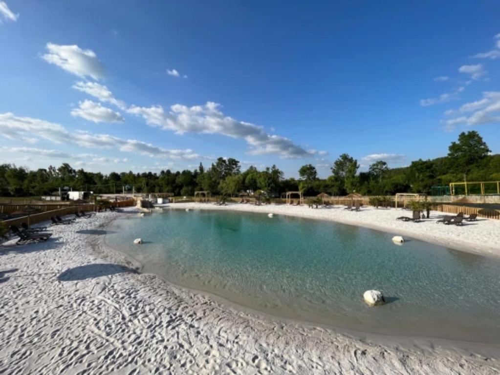 - une grande piscine d'eau sur une plage de sable dans l'établissement Mobilhome 4 étoiles - Piscine - eehicg, à Aubigny