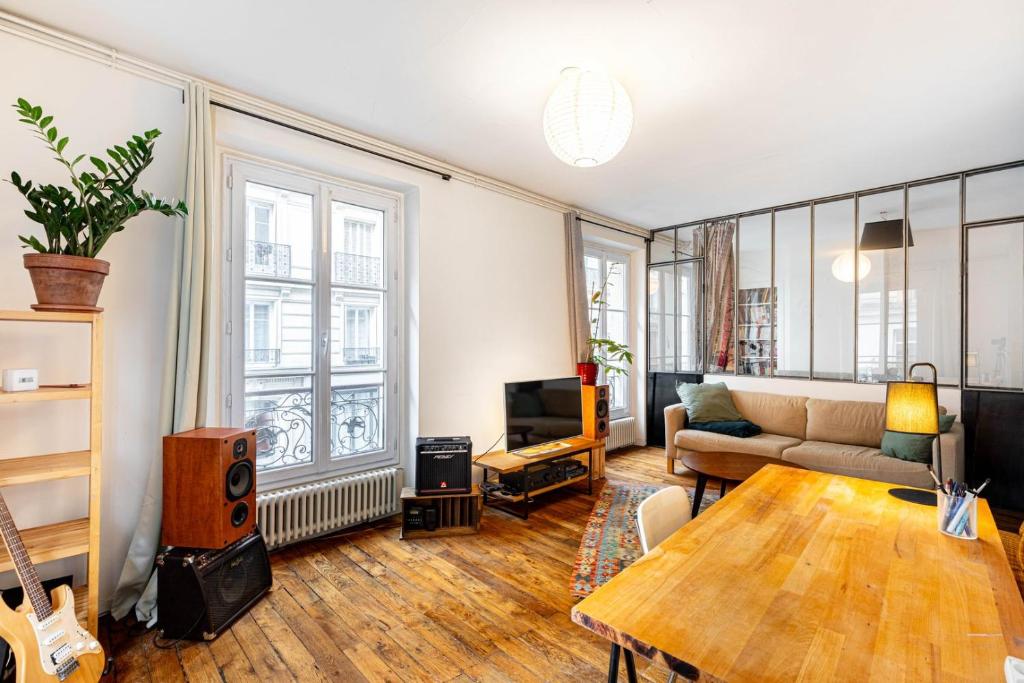 un salon avec un canapé et une table dans l'établissement GuestReady - Séjour Charmant dans le 18ème, à Paris