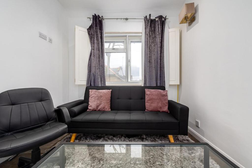 salon z czarną kanapą i szklanym stołem w obiekcie GuestReady - Petite Perfection near Battersea Park w Londynie