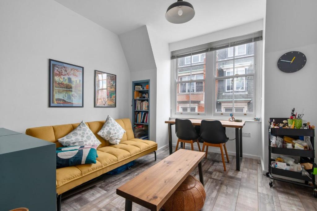 GuestReady - Bright flat in Westminster في لندن: غرفة معيشة مع أريكة وطاولة