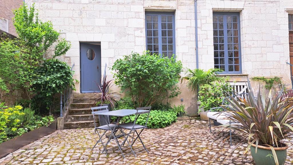 a patio with a table and chairs in front of a building at LA MAISON CANONIALE luxe et charme au coeur de Tours in Tours