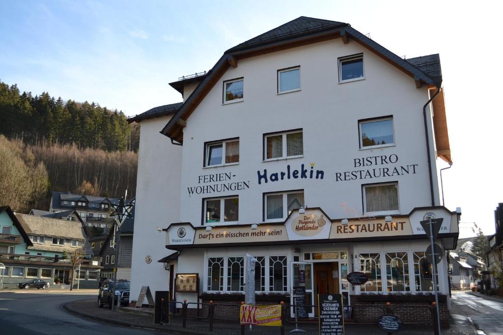 a large white building withcriptions on it on a street at Aparthotel Harlekin in Willingen