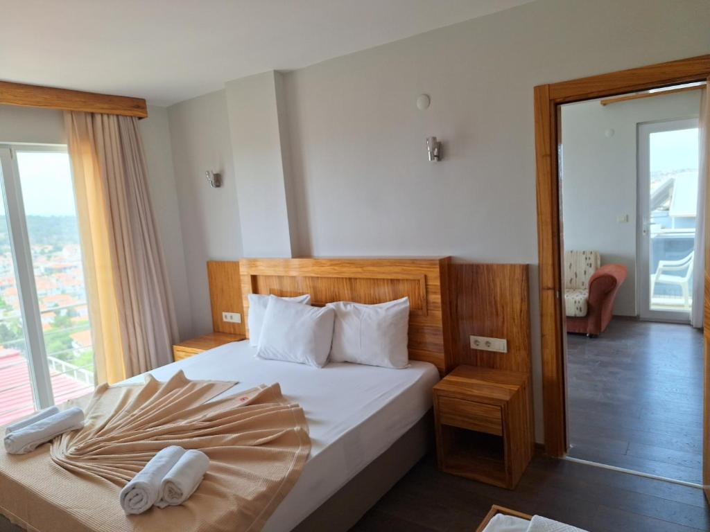 チェシメにあるMy Solmaz Hotelのベッドルーム1室(白いシーツ付きのベッド1台、窓付)