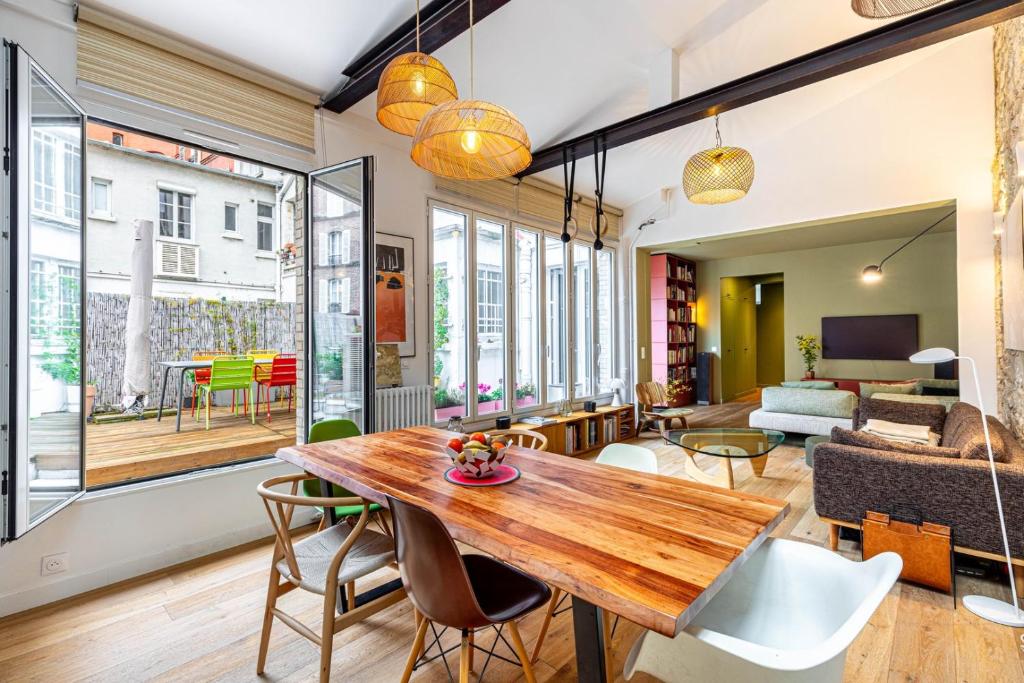 un salon avec une table et des chaises en bois dans l'établissement GuestReady - Bright retreat with a terrace, à Paris