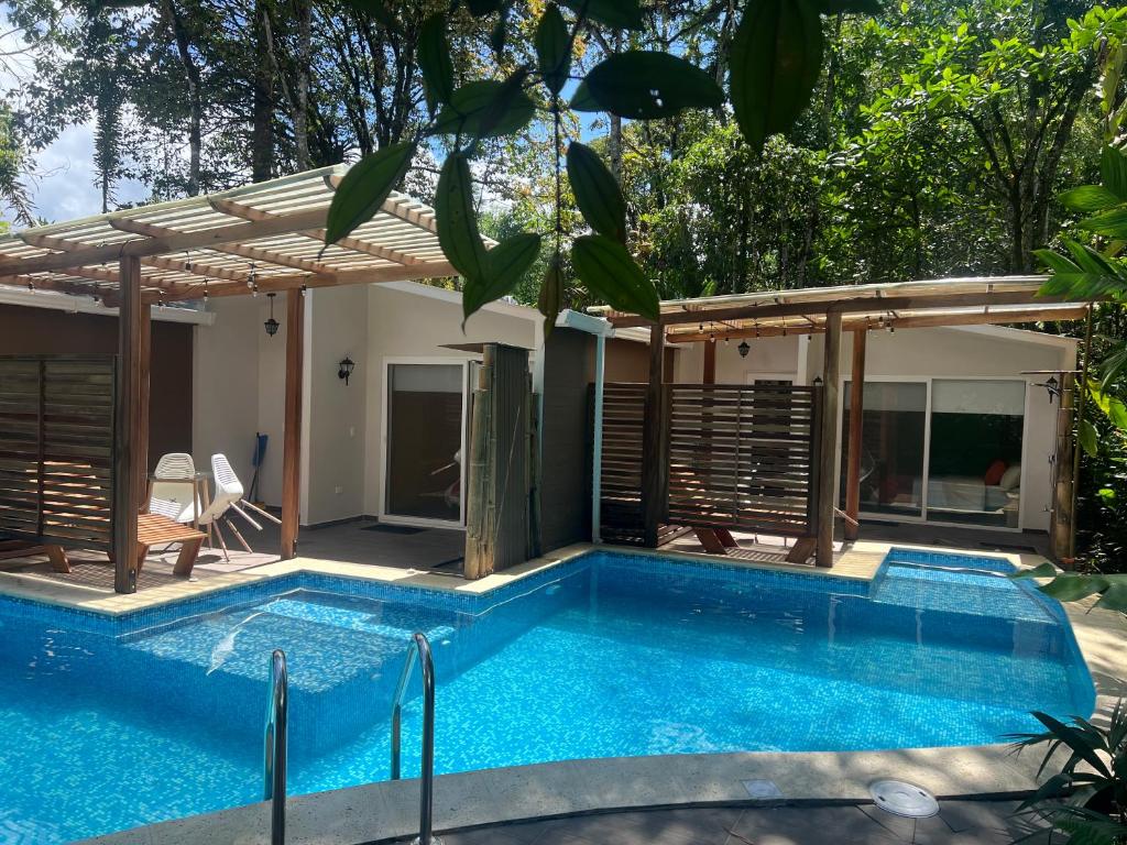 a swimming pool in front of a house at Subtropica Premium Suites - Mindo in Mindo