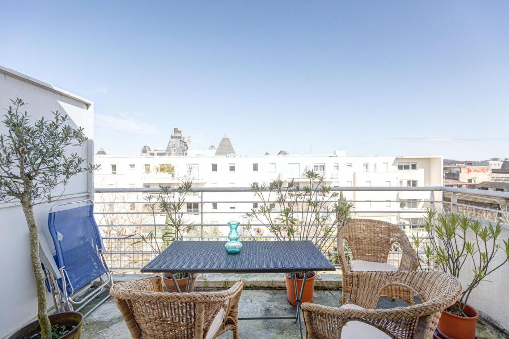 une table et des chaises sur un balcon avec vue dans l'établissement GuestReady - Beau Séjour près de Saint-Michel, à Bordeaux