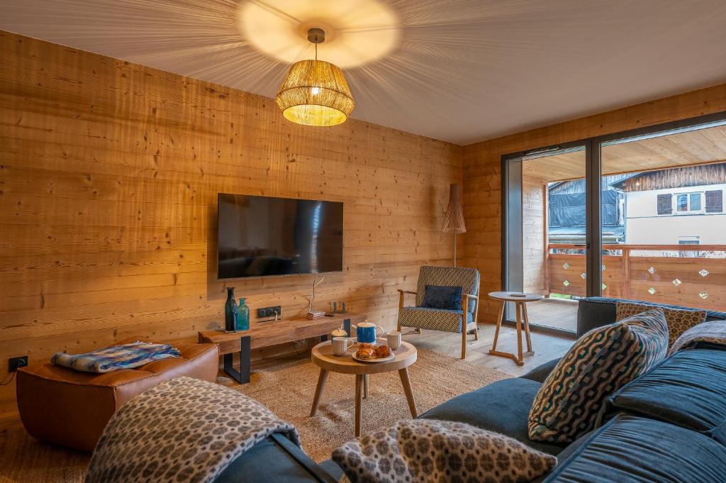 un salon avec un canapé et une télévision dans l'établissement Cairn Harmony - Apartment B209, aux Gets