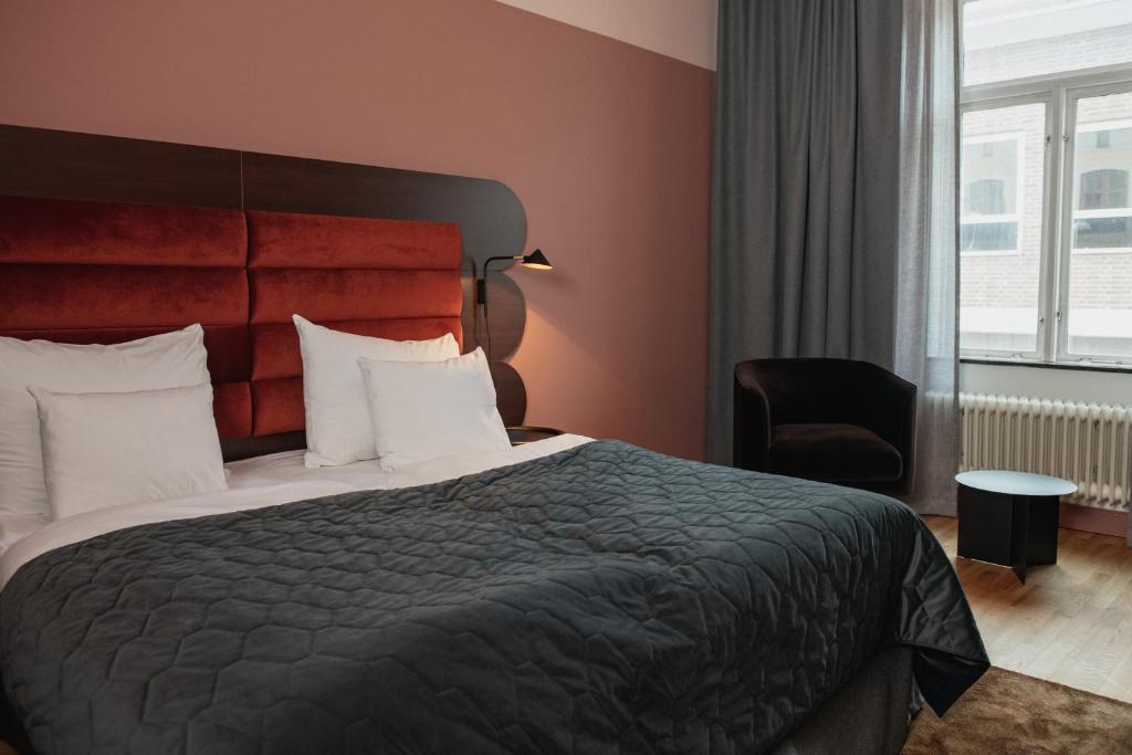 ein Hotelzimmer mit einem Bett und einem Stuhl in der Unterkunft Clarion Hotel Örebro in Örebro