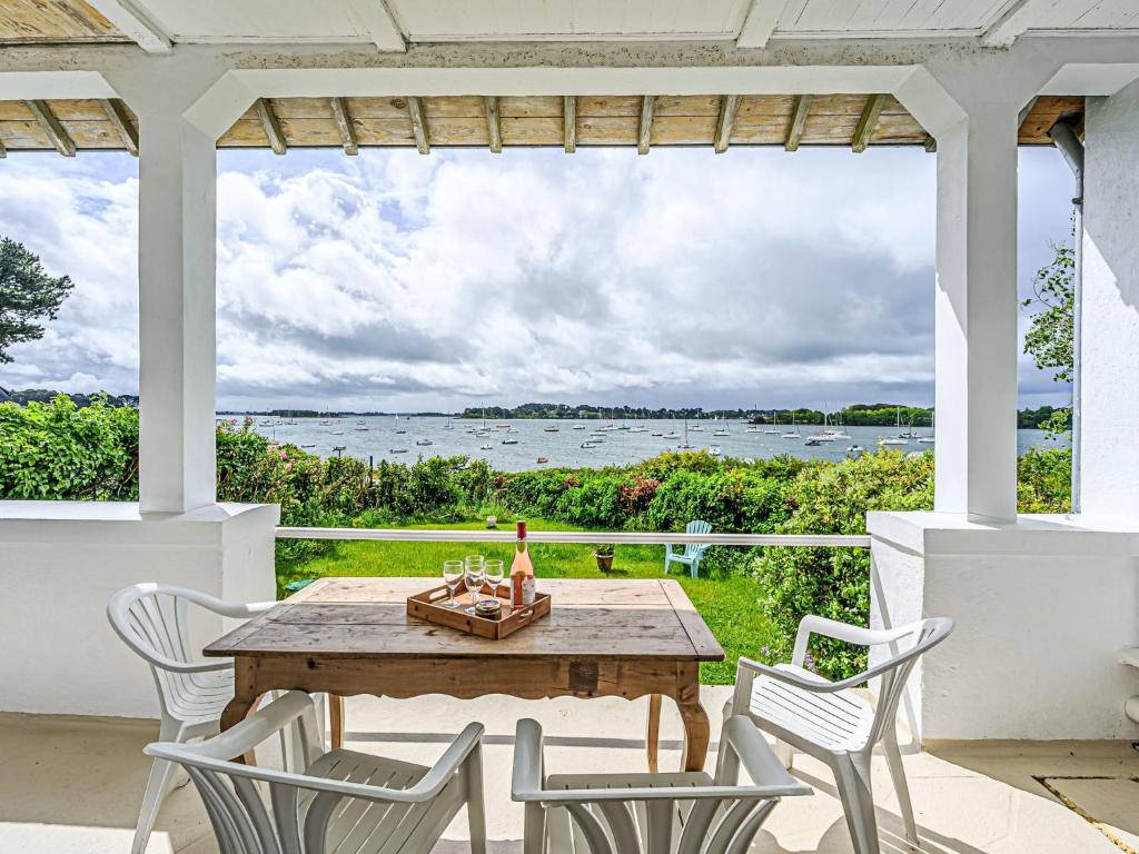 a table and chairs on a patio with a view of the water at Holiday Home Maison La Prâme by Interhome in Arradon