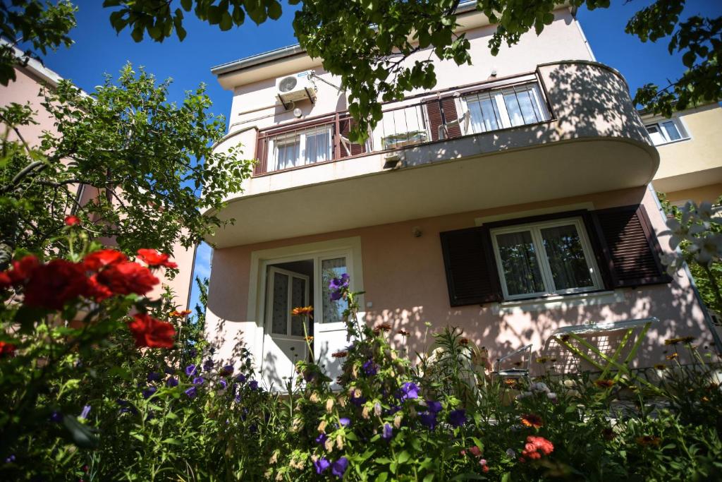 una casa con flores delante en Apartmani Vitković II Cres en Cres
