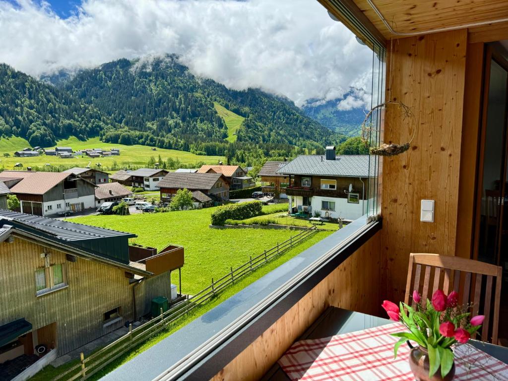einen Balkon mit einem Tisch und Bergblick in der Unterkunft Ferienwohnung Schoppernau in Schoppernau