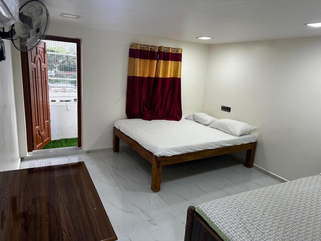 Pokój z łóżkiem i oknem z zasłoną w obiekcie Temple View Home Stay w mieście Tiruvannamalai