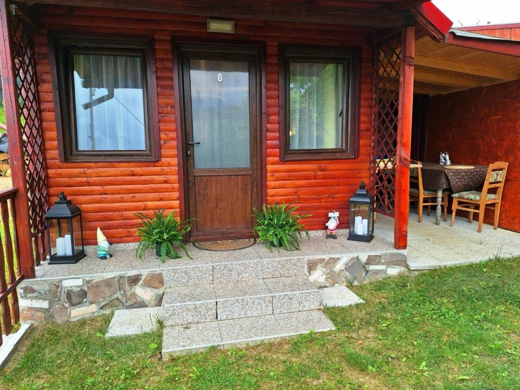 a house with a wooden door and a table at Chalet Tinelu Brașov Săcele in Săcele