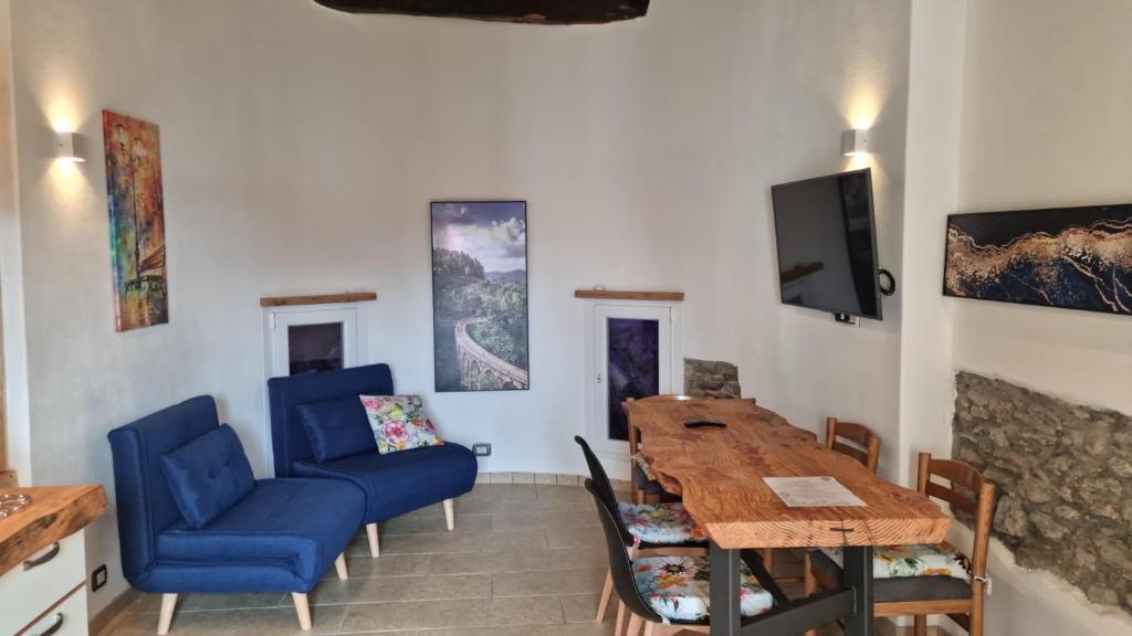 ein Wohnzimmer mit einem Esstisch und einem TV in der Unterkunft Il Rustico in Maccagno Superiore