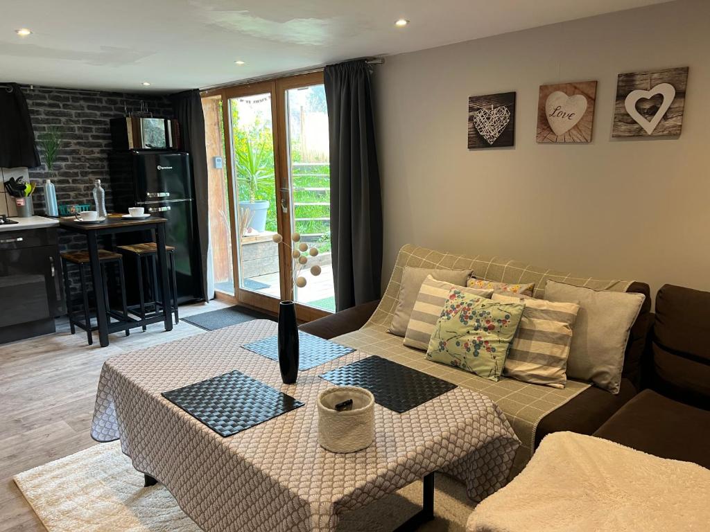 una sala de estar con un sofá y una mesa en Les Saisies - La petite Vardache - studio alcôve 27 m2 - 1 lit 140 - parking - local vélo, en Hauteluce