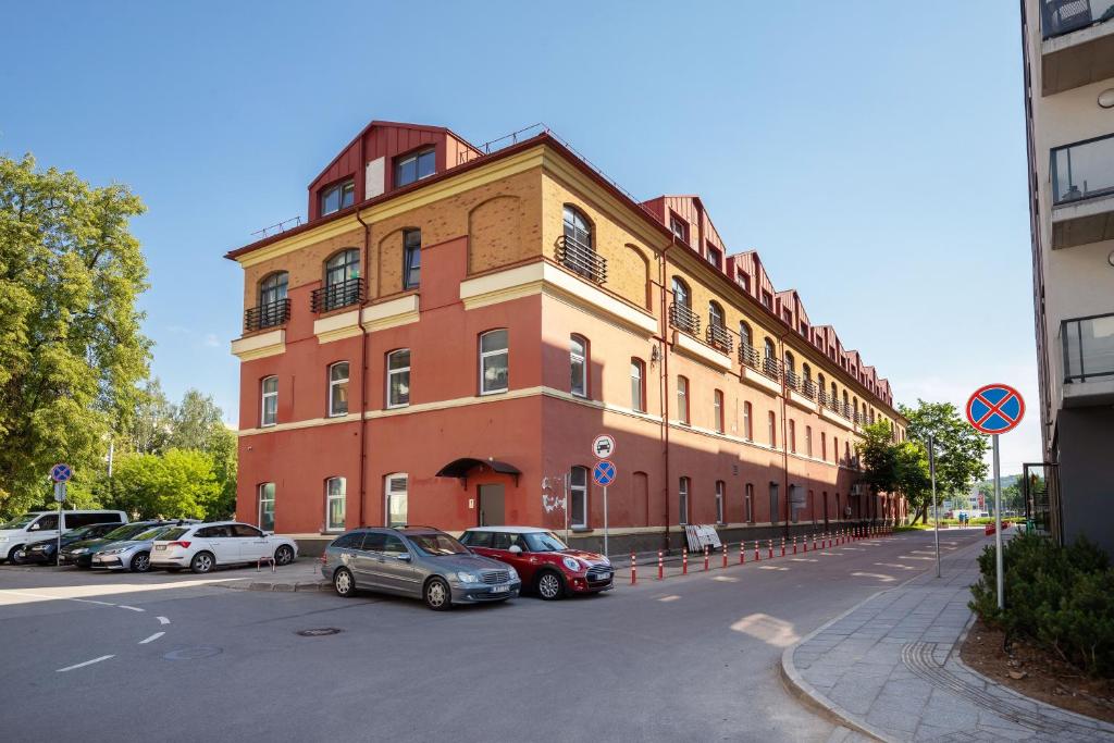a large brick building with cars parked in front of it at StudioApart23 in Vilnius