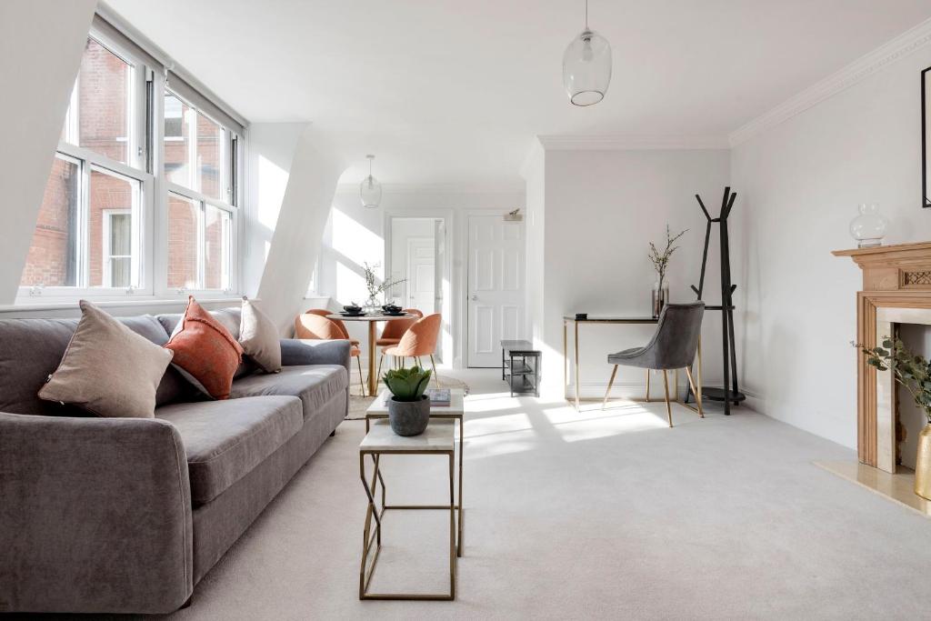 ein Wohnzimmer mit einem Sofa und einem Tisch in der Unterkunft 3 Sloane Gardens in London