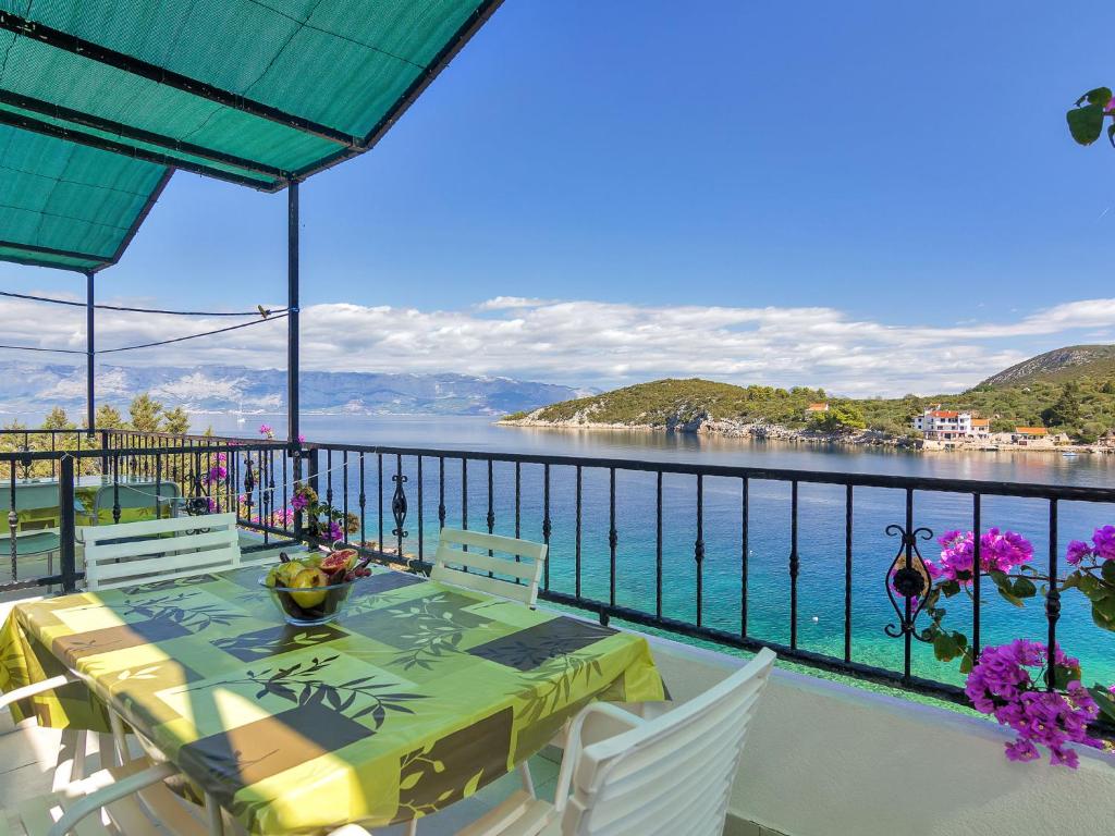 a table and chairs on a balcony with a view of the water at Apartment Rubin-8 by Interhome in Zastražišće