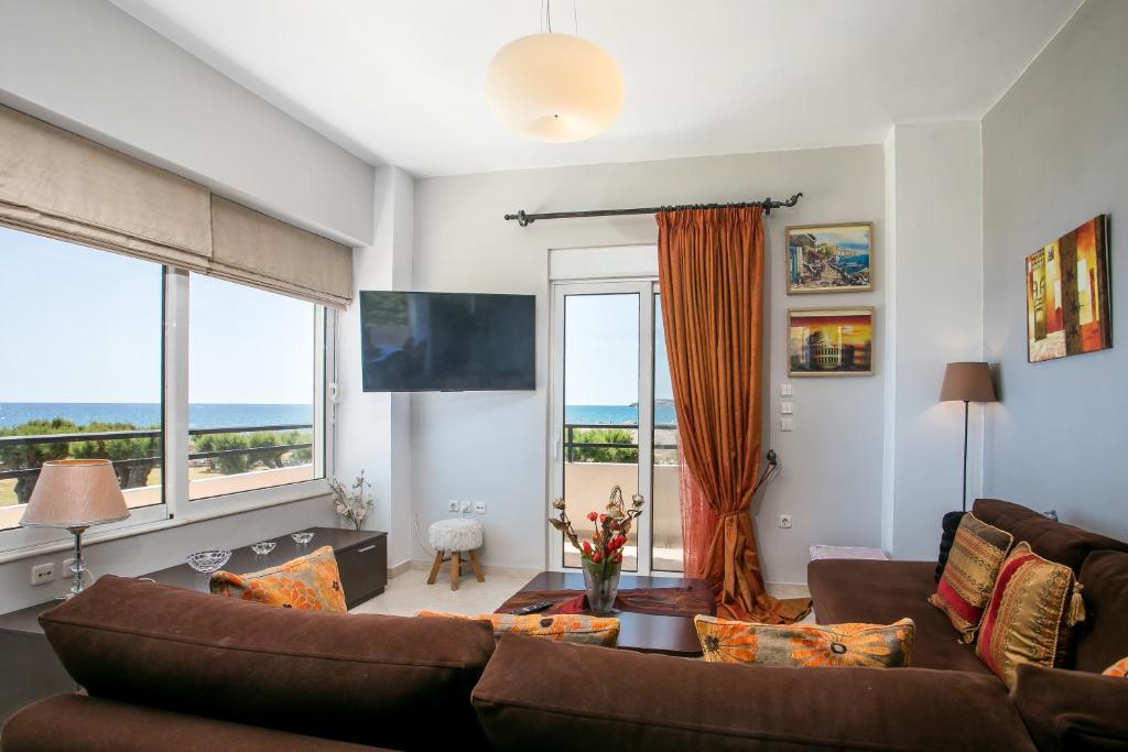 a living room with a couch and a large window at Al Mare Apartments in Afantou