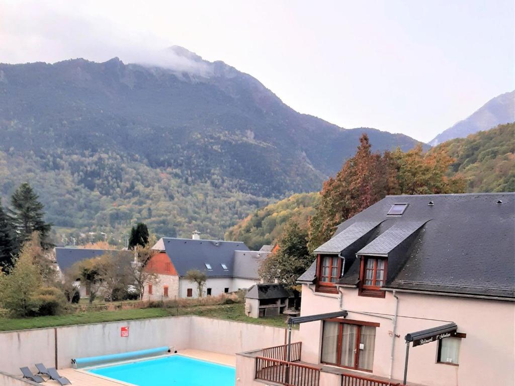 una casa con piscina di fronte a una montagna di Appartement Confort 2 Pièces à Vignec avec Piscine et Proche Saint-Lary-Soulan - FR-1-504-424 a Vignec