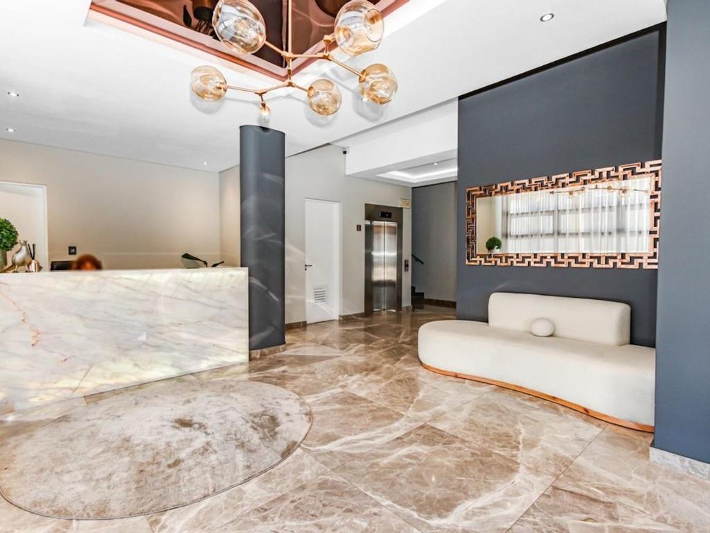 a living room with a large marble floor and a couch at OAM The Paramount Rosebank Luxury One-Bedroom in Johannesburg